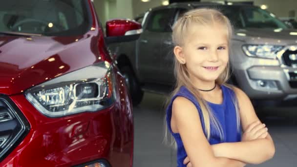 ein süßes Mädchen steht auf dem Hintergrund des Autos und lacht - Filmmaterial, Video