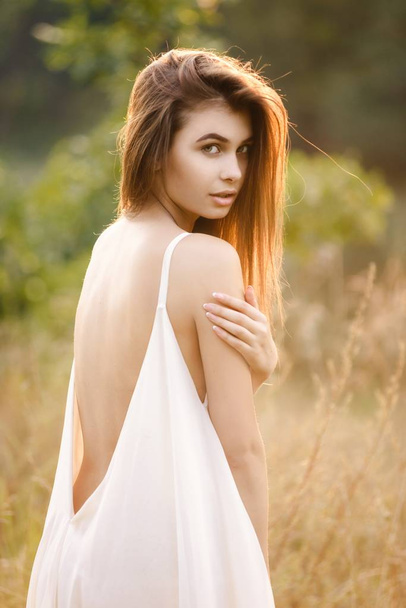 Young woman in long white dress posing  on nature - Photo, Image