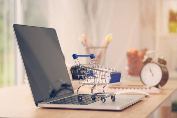 Mini shopping cart on computer laptop. Business concept. - Photo, image