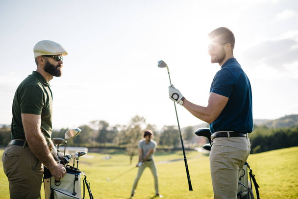 friends spending time on golf course - Foto, imagen