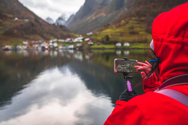 Turisti ottaa kuvia norjalaisista vuonoista älypuhelimella
  - Valokuva, kuva