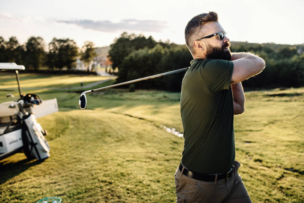 Man playing golf on a golf course - Foto, Bild