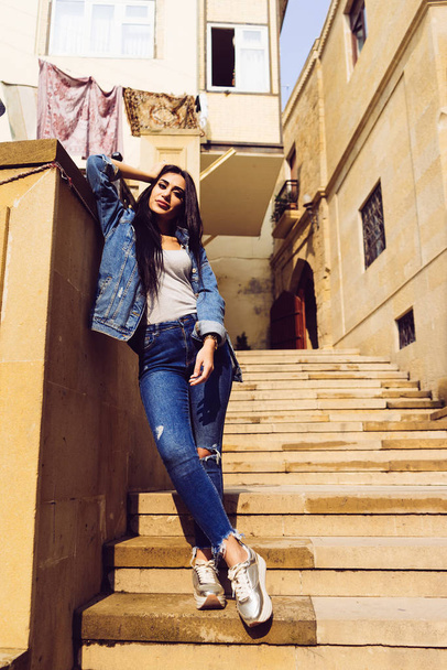 stylish young tourist girl travels through the cities of Europe, walks the streets of Baku, in Azerbaijan, poses - 写真・画像