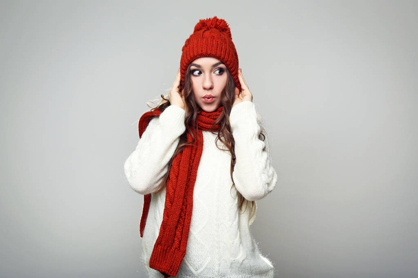 Beautiful young girl in sweater, scarf and hat on grey background - Foto, imagen