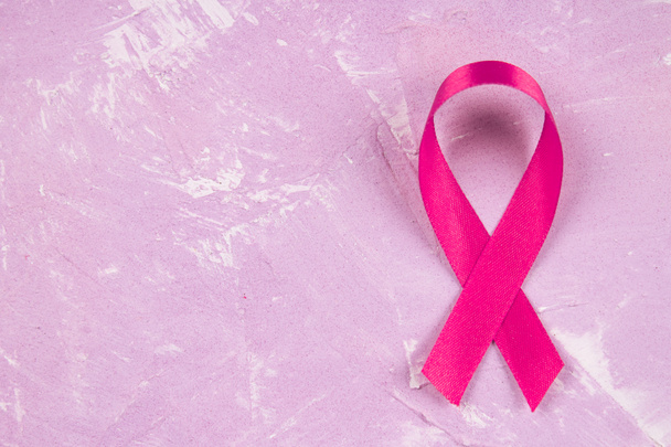 Overhead view of Breast Cancer ribbon against pink background. - Fotografie, Obrázek