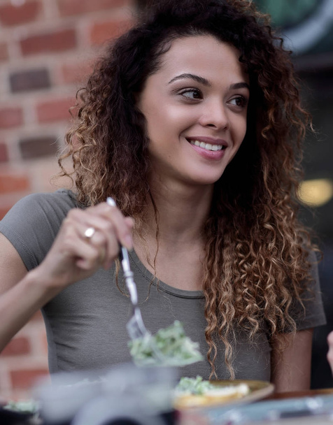 Young woman enjoying food at a street cafe in the hot summer sun - Φωτογραφία, εικόνα