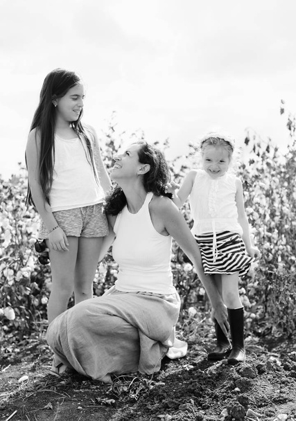 Portrait of beautiful mother with two daughters outdoors - Photo, Image