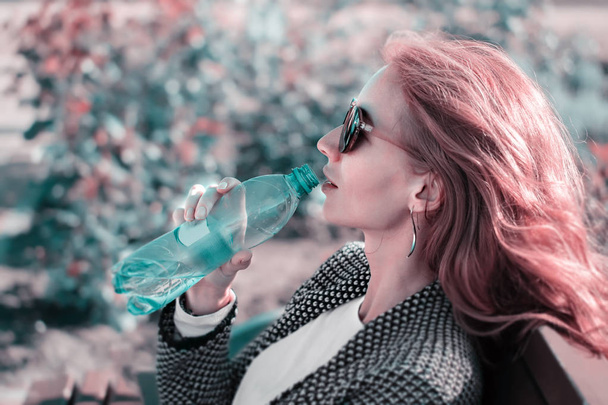 la fille rousse aux lunettes de soleil avec bouteille d'eau
 - Photo, image