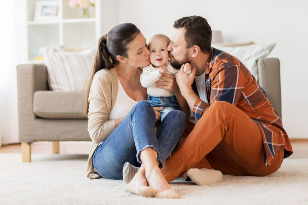 happy mother and father kissing baby at home - Foto, Bild