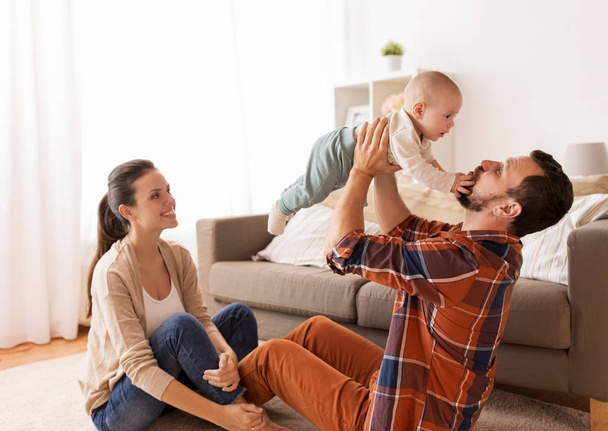 happy mother and father playing with baby at home - Φωτογραφία, εικόνα
