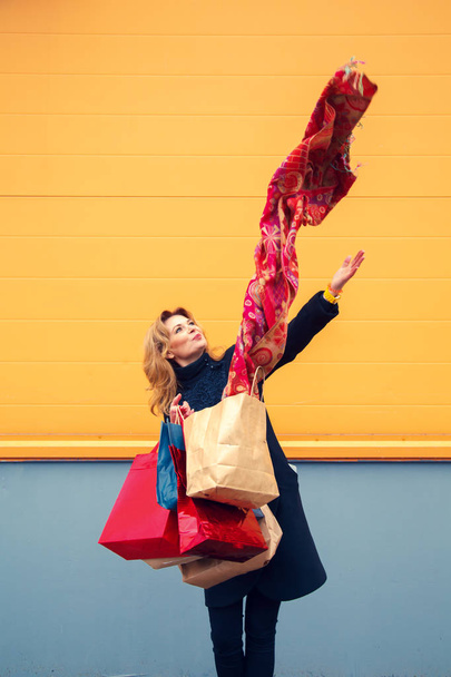 Beautiful woman with shopping bags looking at purchases.  - Photo, Image