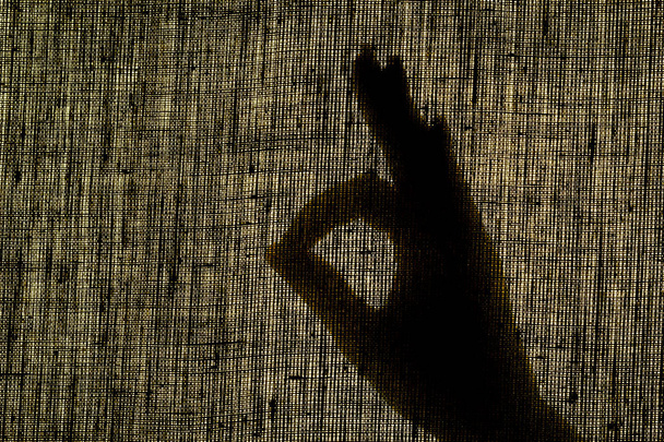 Stínová ruka ukazuje gesto, jako gesto na opotřebené hadřík. - Fotografie, Obrázek