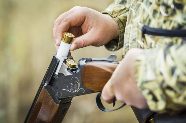 Man charging double-barreled hunting rifle closeup. - Φωτογραφία, εικόνα