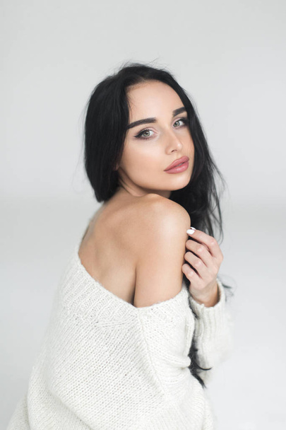 portrait of a beautiful girl in a white sweater - Фото, зображення