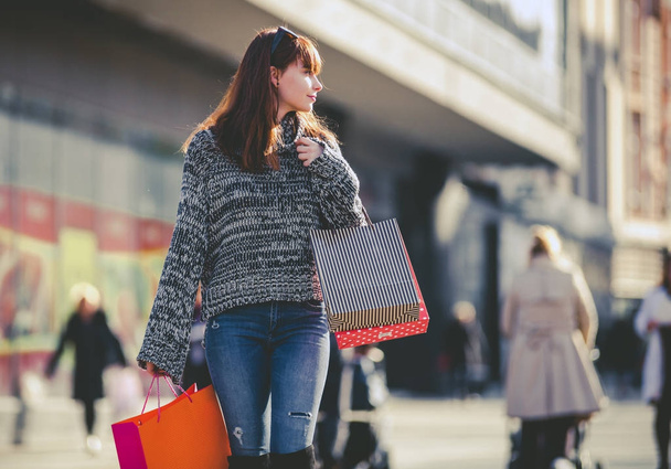 Woman with shopping bags walking on street, city scene - Zdjęcie, obraz
