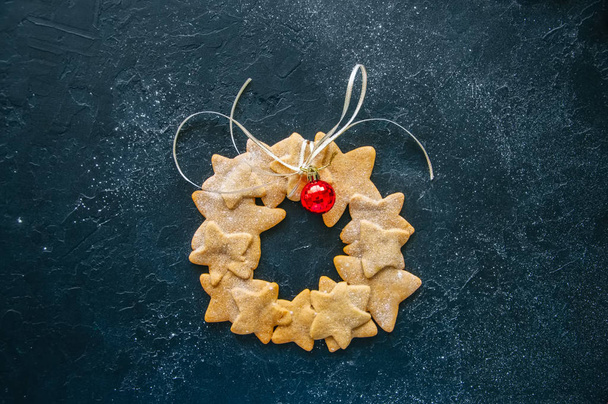 Gingerbread star cookies wreath with white ribbon sprinkled with - Fotó, kép