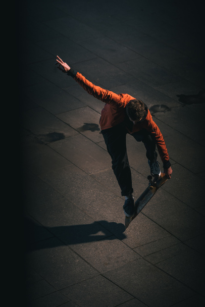 high angle view of skateboarder balancing on board at late night - Фото, изображение