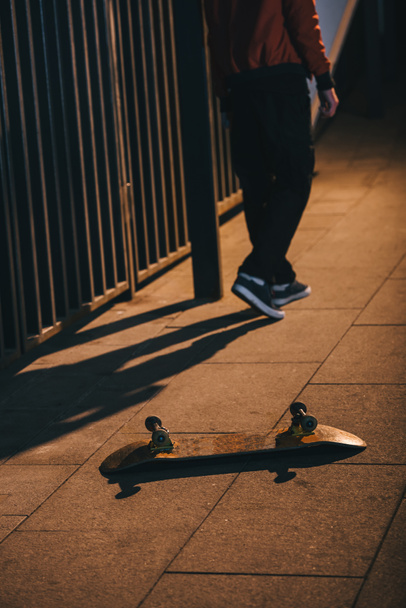 cropped shot of man walking away from skateboard laying on floor - Foto, Imagem