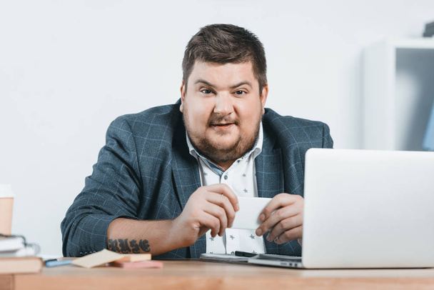 fat businessman in suit working with smartphone and laptop at workplace - Foto, immagini