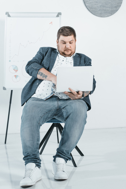 overweight businessman in suit working with laptop in office - Фото, изображение