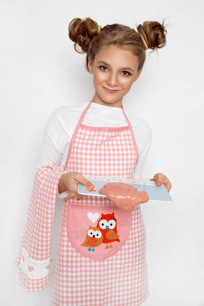 Cute funny girl with slime in the kitchen. The girl cooks and bakes her muffins, makes a cake and slime. - Photo, Image
