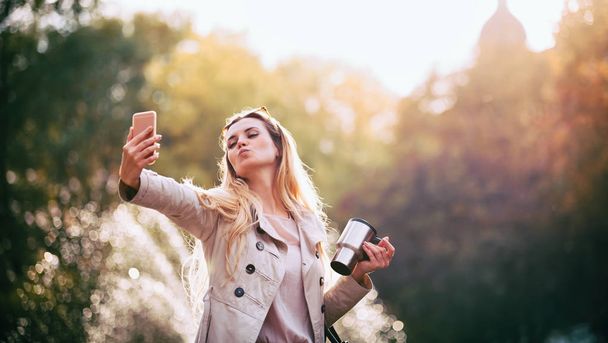 Modern woman in city taking selfie photo on smartphone outdoor - Photo, Image