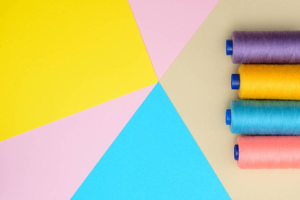 Werkzeugkasten zum Schneiden, Nähen auf gelbem, rosa, blauem Hintergrund mit einer Leerstelle unter einer Beschriftung in der Mitte. Draufsicht, flache Lage. Mode-Minimalismus - Foto, Bild