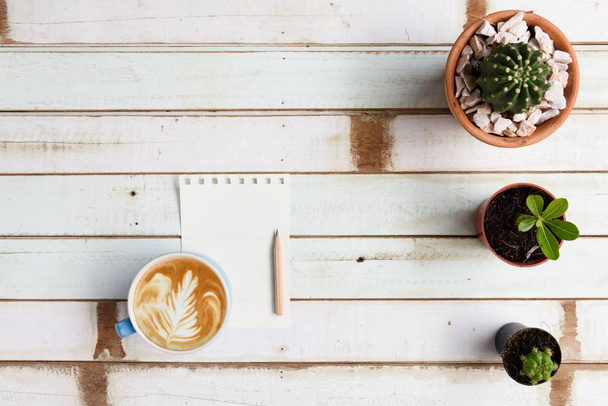 Bureau de jardinage plat avec plantes de cactus en pot, et café latte art sur fond de bois vintage, vue de dessus
 - Photo, image