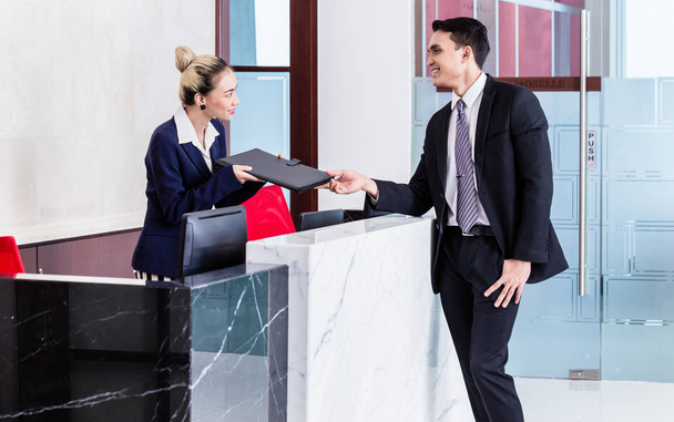 Applicant giving his documents to receptionist - Φωτογραφία, εικόνα