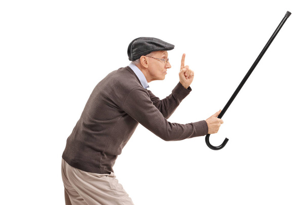 senior holding his cane as a sword and gesturing - Foto, afbeelding