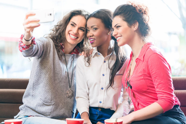 Młodych kobiet w café biorąc selfie - Zdjęcie, obraz