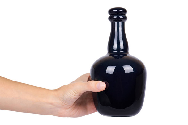 Beautiful black bottle in hand isolated on white background, expensive alcohol, luxury drink - Zdjęcie, obraz