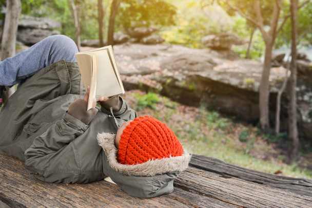 Asian boy reading a book on park in relax time winter season - Zdjęcie, obraz