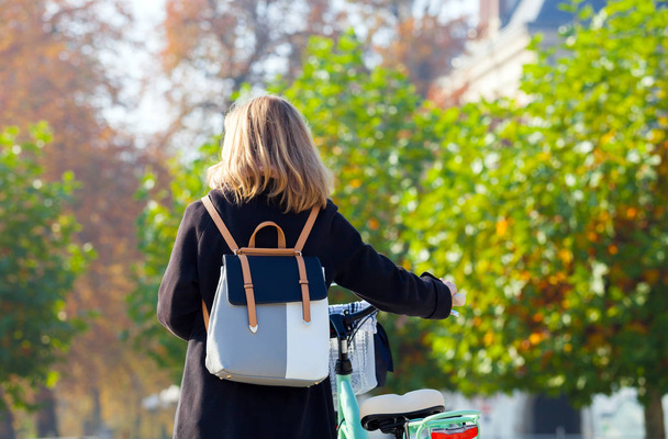 Woman with vintage bike in the city during autumn - Fotoğraf, Görsel