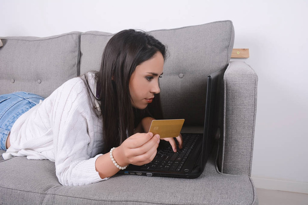 Woman holding credit cart and using laptop. - Fotó, kép