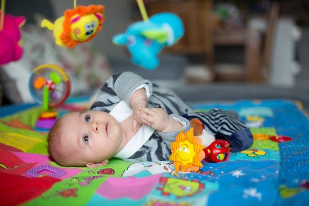 Happy three months old baby boy, playing at home on a colorful a - Foto, imagen