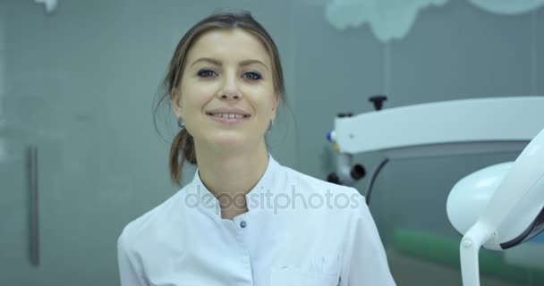 Smiling dentist put her medical mask on face. - Video