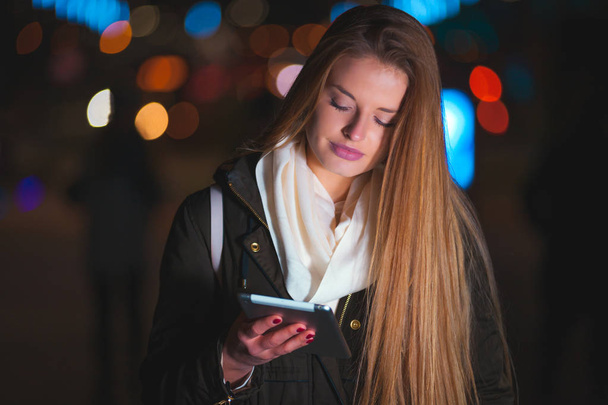 Beautiful woman using tablet in the city at night - Fotoğraf, Görsel