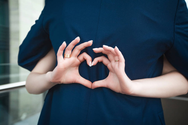 Bride making heart with fingers on grooms back - 写真・画像