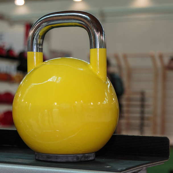 Mancuerna amarilla en el gimnasio: Equipo de fitness de peso
 - Foto, Imagen
