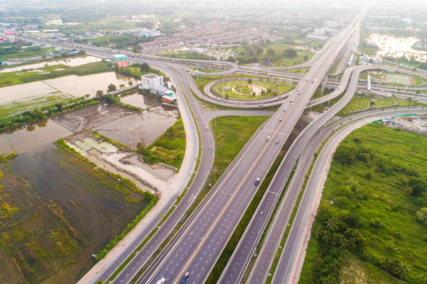 Vista superior de la carretera de intersección de tráfico Overpas con árbol verde por la mañana, concepto de transporte
 - Foto, Imagen
