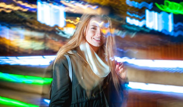 Vrouw in de stad bij nacht onder de neon lichten verplaatsen - Foto, afbeelding
