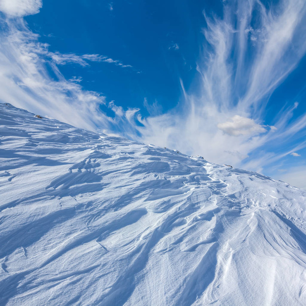 winter snowbound mount slope on a blue sky background - Zdjęcie, obraz