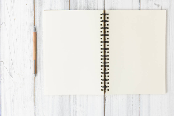 Notebook e lápis marrom sobre fundo mesa de madeira branca, plana la
 - Foto, Imagem