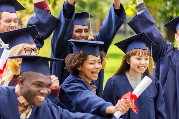 estudantes felizes em placas de argamassa com diplomas - Foto, Imagem
