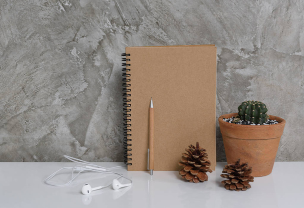 Memo notebook,pencil ,cactus and earphone on white table art bac - Photo, Image