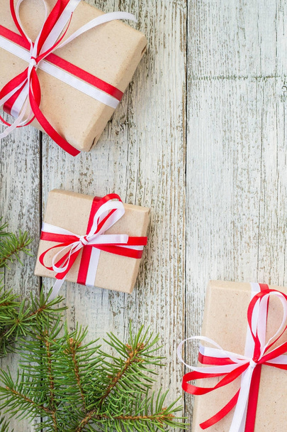 Frontera de cajas de regalo de Navidad y rama de abeto en mesa de madera
. - Foto, Imagen
