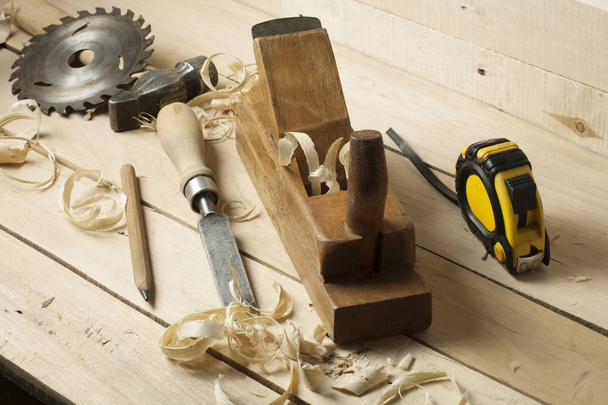Concepto de carpintería.Empleado carpintero carpintero. Herramientas de construcción sobre mesa de madera con serrín
. - Foto, imagen