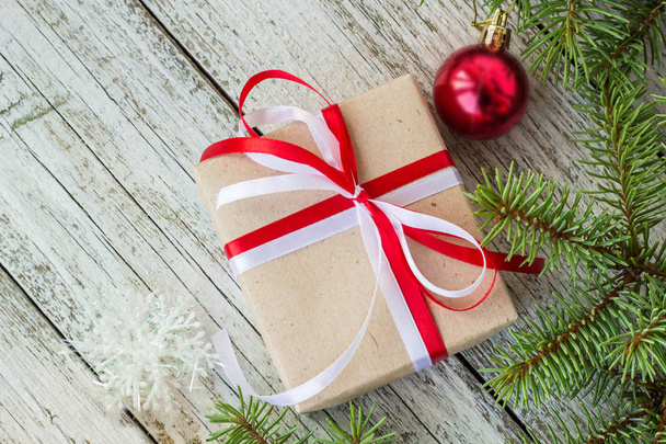 Draufsicht auf Rahmen aus Weihnachtsschmuck, Geschenkschachteln, Tannenzweigen auf weißem Holzgrund mit Kopierraum - Foto, Bild