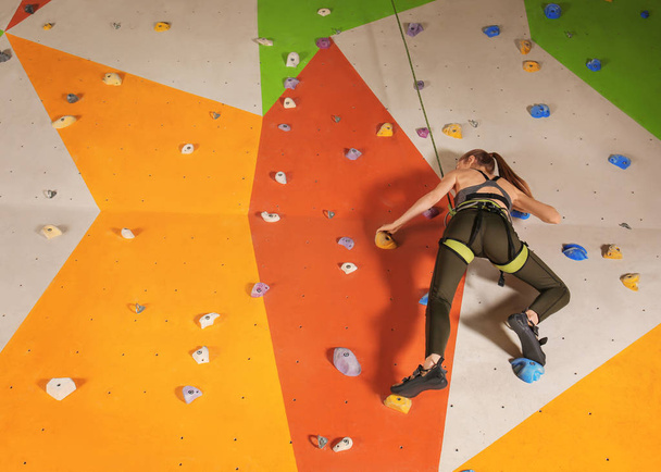 Young woman exercising in climbing gym - Photo, image